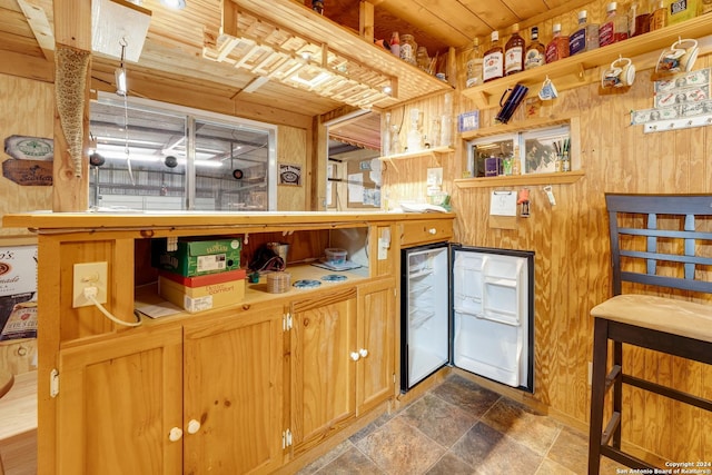 kitchen featuring white refrigerator, wooden walls, and wood ceiling