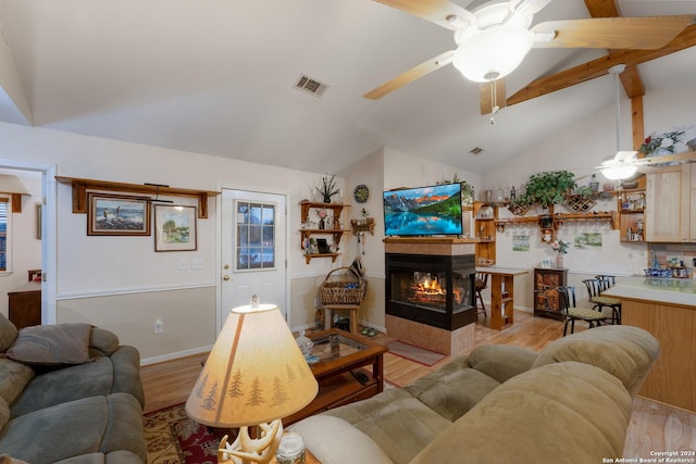 living room featuring ceiling fan, a multi sided fireplace, high vaulted ceiling, and light hardwood / wood-style flooring