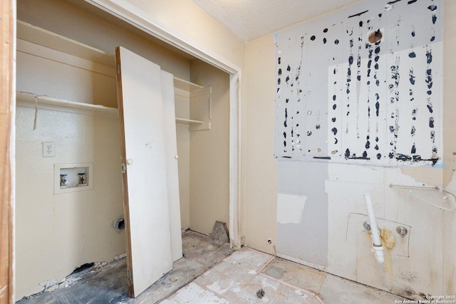 washroom with a textured ceiling and hookup for a washing machine