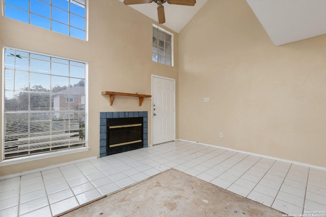 unfurnished living room featuring ceiling fan, light tile patterned floors, high vaulted ceiling, and a tiled fireplace