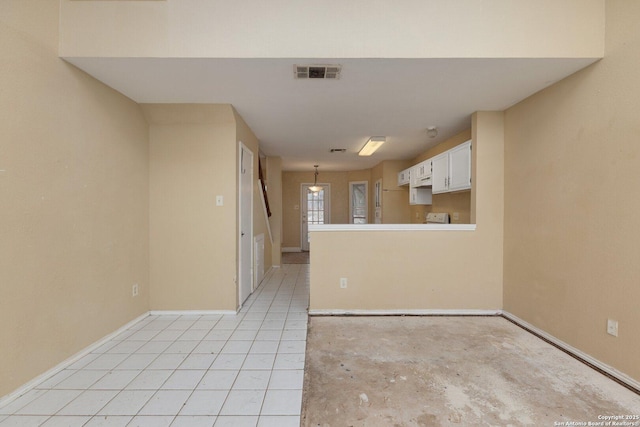 interior space featuring kitchen peninsula and white cabinets