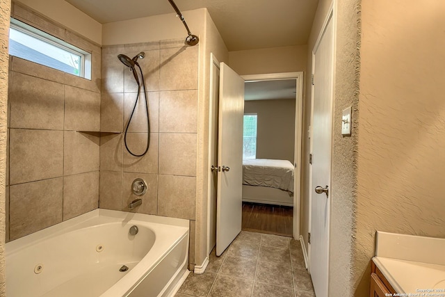 bathroom with tile patterned floors, vanity, and tiled shower / bath