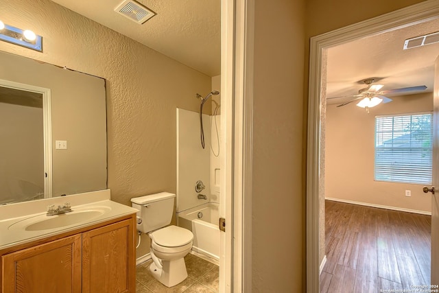 full bathroom with vanity, hardwood / wood-style flooring, toilet, a textured ceiling, and shower / bathtub combination