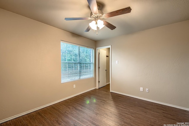 unfurnished room with ceiling fan and dark hardwood / wood-style flooring