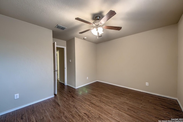 spare room featuring dark hardwood / wood-style floors, ceiling fan, and a textured ceiling