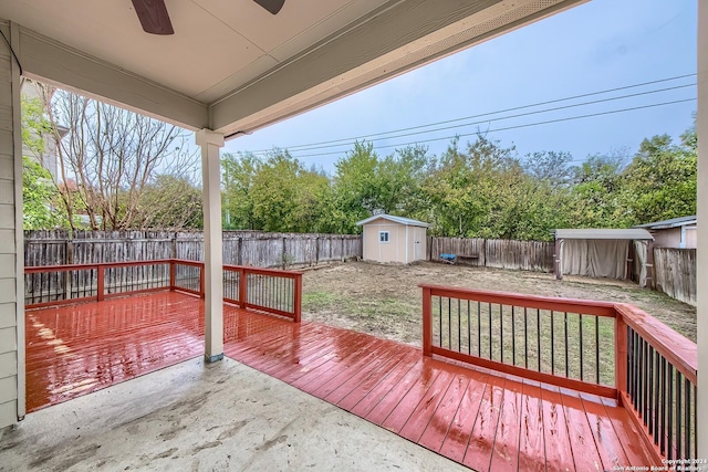 wooden deck with ceiling fan and a storage shed