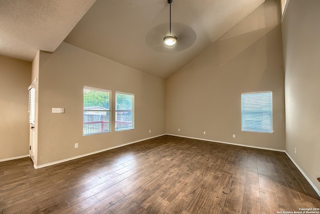 empty room featuring ceiling fan, dark hardwood / wood-style flooring, a textured ceiling, and vaulted ceiling