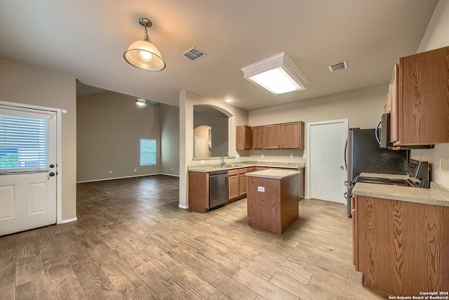 kitchen with a center island, sink, light wood-type flooring, and stainless steel appliances