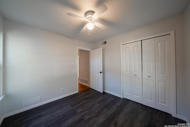 unfurnished bedroom featuring ceiling fan, dark wood-type flooring, and a closet