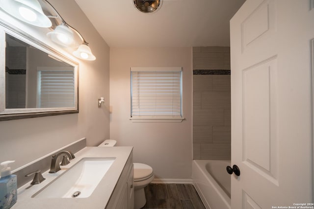 full bathroom featuring vanity, toilet, wood-type flooring, and tiled shower / bath combo