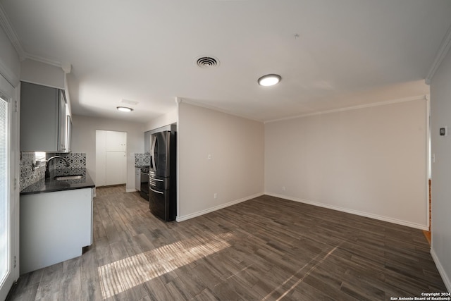 interior space featuring dark hardwood / wood-style flooring, ornamental molding, and sink