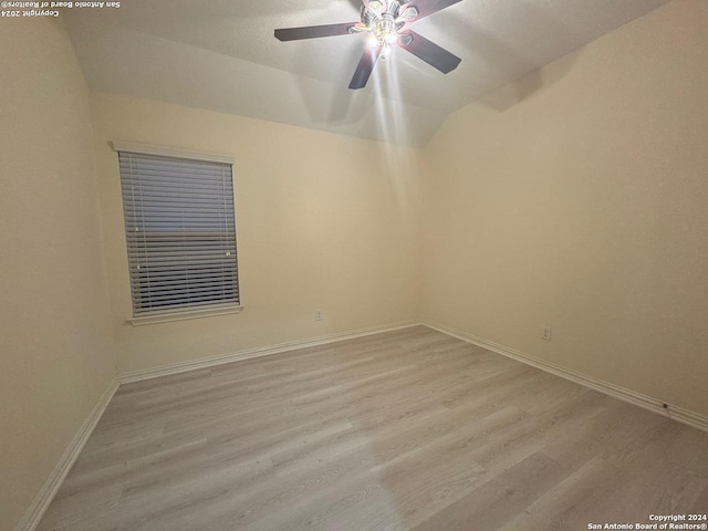 empty room with ceiling fan, light hardwood / wood-style flooring, and lofted ceiling