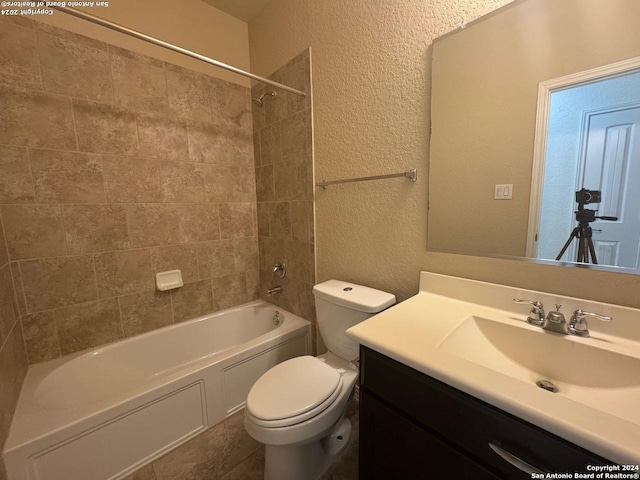 full bathroom with vanity, tiled shower / bath combo, and toilet