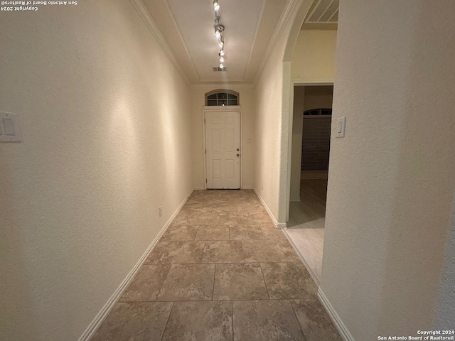 corridor featuring ornamental molding and track lighting