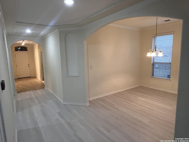 unfurnished room featuring a chandelier and light wood-type flooring