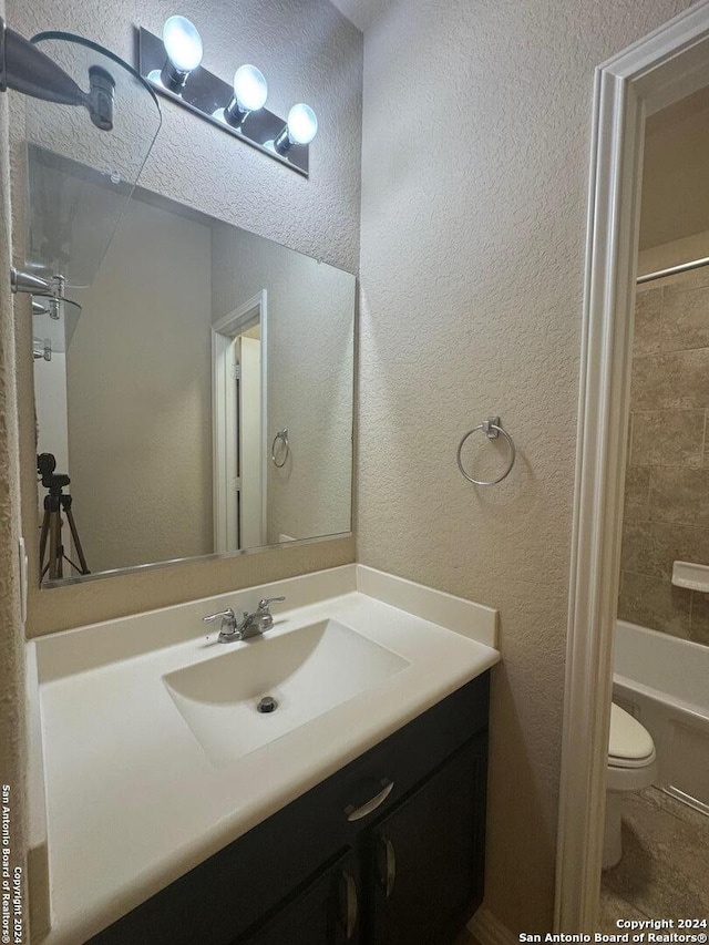 full bathroom with vanity, toilet, and tiled shower / bath