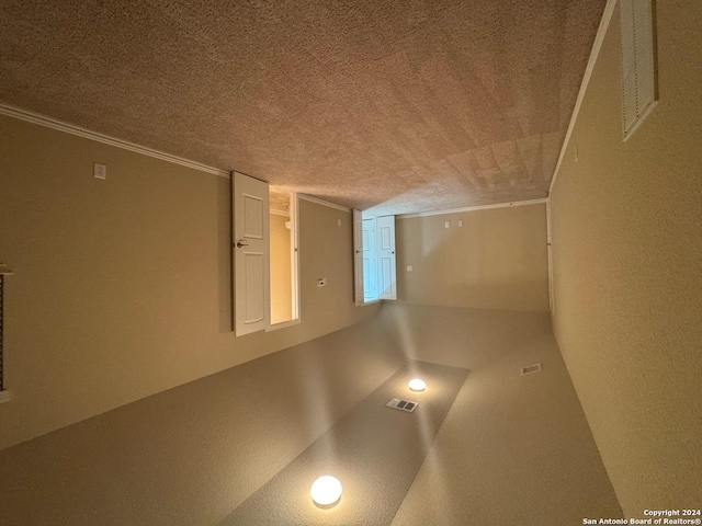 basement with a textured ceiling and ornamental molding