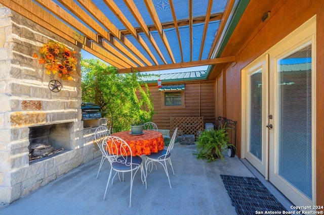 view of patio featuring a pergola and an outdoor stone fireplace