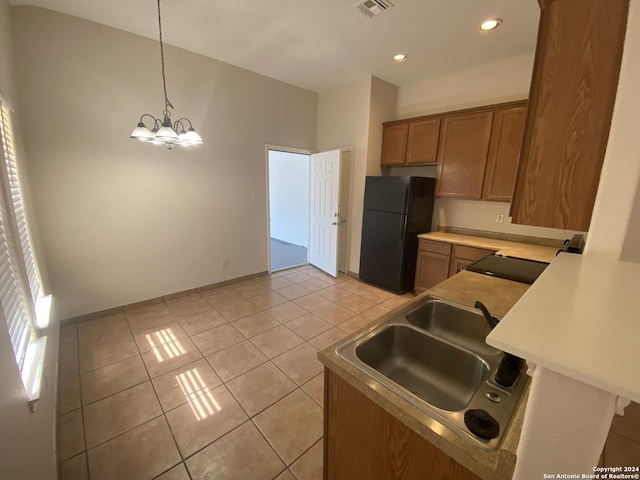 kitchen with sink, black fridge, a notable chandelier, decorative light fixtures, and light tile patterned flooring