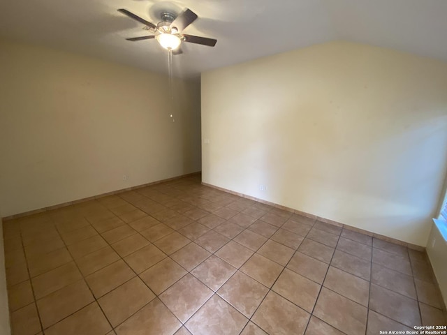 tiled empty room featuring ceiling fan and lofted ceiling