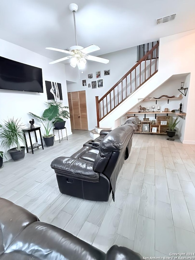 living room with light wood-type flooring and ceiling fan