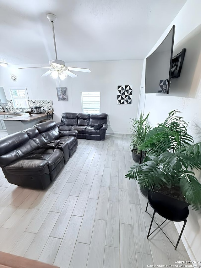 living room featuring light hardwood / wood-style flooring and ceiling fan