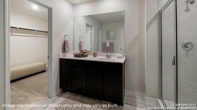 bathroom featuring a shower with door, vanity, and tile patterned flooring