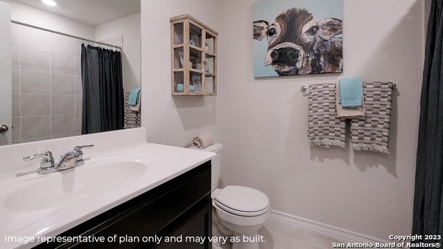 bathroom with tile patterned flooring, vanity, toilet, and curtained shower