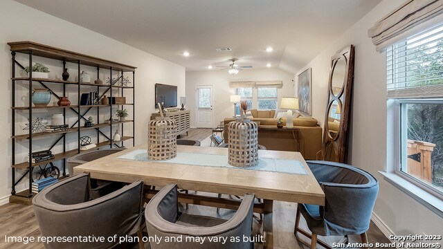 dining room with hardwood / wood-style floors, ceiling fan, and lofted ceiling