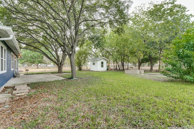 view of yard with a storage unit and a patio