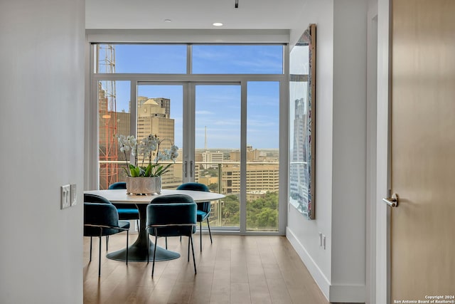 dining room with light hardwood / wood-style flooring and a wall of windows