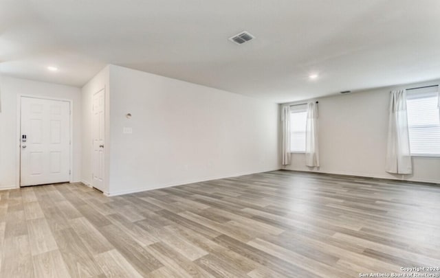 unfurnished room featuring light hardwood / wood-style flooring and a wealth of natural light