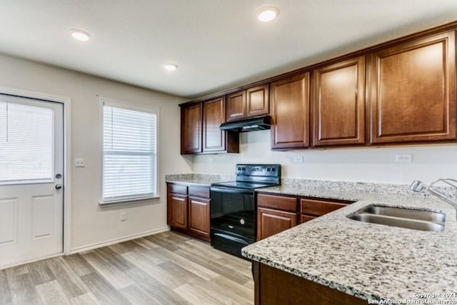 kitchen with light hardwood / wood-style floors, light stone countertops, black range with electric stovetop, and sink