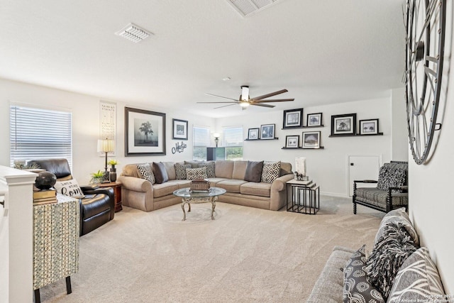 living room with a textured ceiling, light colored carpet, and ceiling fan