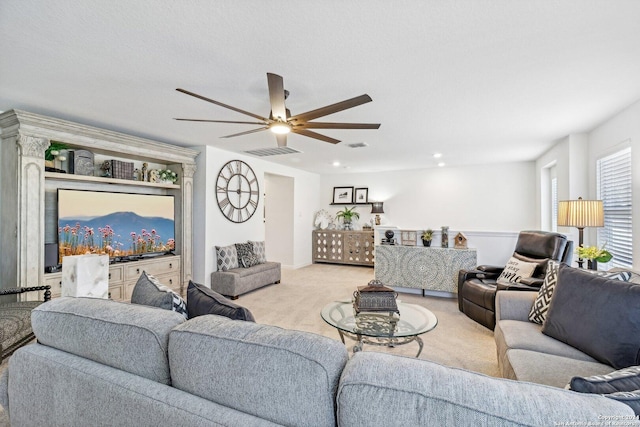 living room featuring ceiling fan, light colored carpet, and a textured ceiling