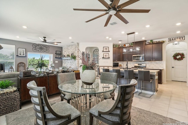 dining area with ceiling fan, sink, and light tile patterned floors