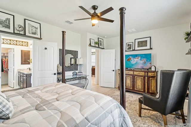 tiled bedroom featuring ceiling fan, sink, and ensuite bath