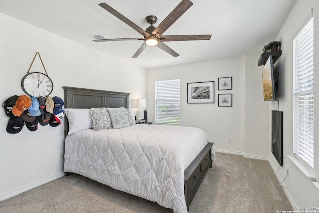 carpeted bedroom featuring multiple windows and ceiling fan