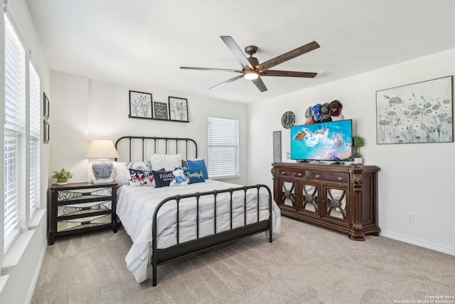 bedroom with multiple windows, ceiling fan, and carpet