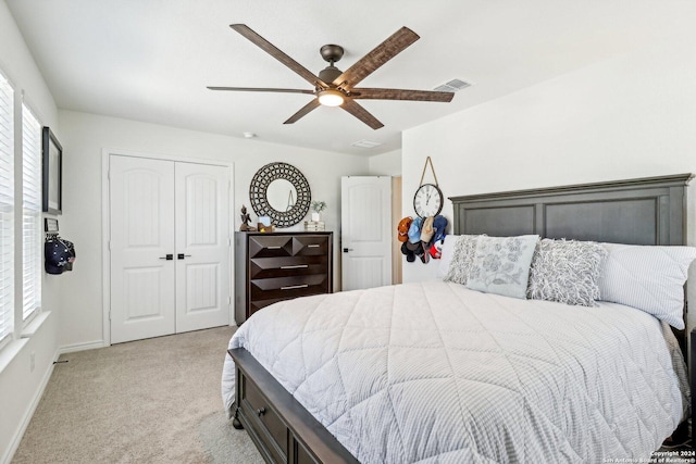 bedroom with ceiling fan, a closet, and light carpet