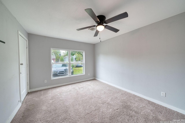 spare room with carpet and ceiling fan