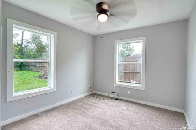 carpeted spare room featuring ceiling fan and a healthy amount of sunlight