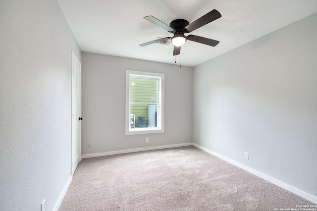 spare room with ceiling fan and carpet