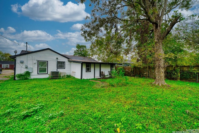 back of property featuring a lawn and central AC unit