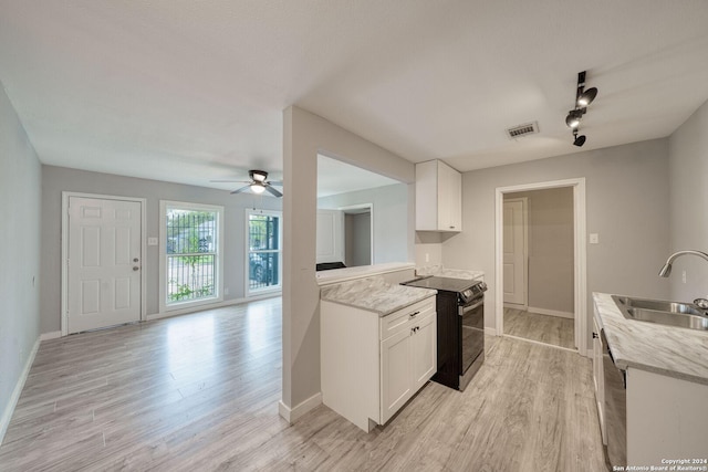 kitchen featuring electric range, sink, white cabinets, and light hardwood / wood-style flooring