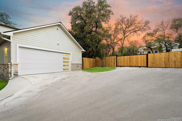 property exterior at dusk featuring a garage