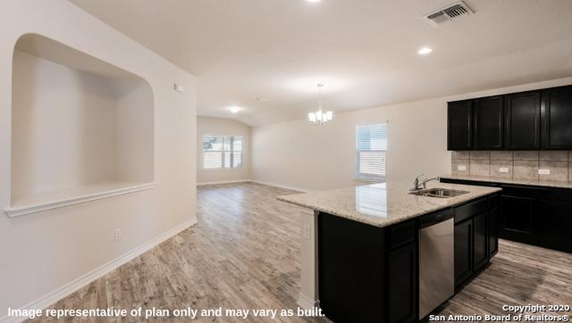 kitchen featuring backsplash, a kitchen island with sink, sink, stainless steel dishwasher, and light hardwood / wood-style floors