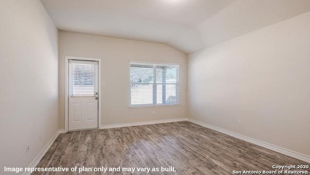 unfurnished room featuring vaulted ceiling and hardwood / wood-style flooring