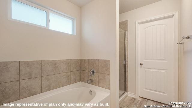 bathroom with hardwood / wood-style flooring and independent shower and bath