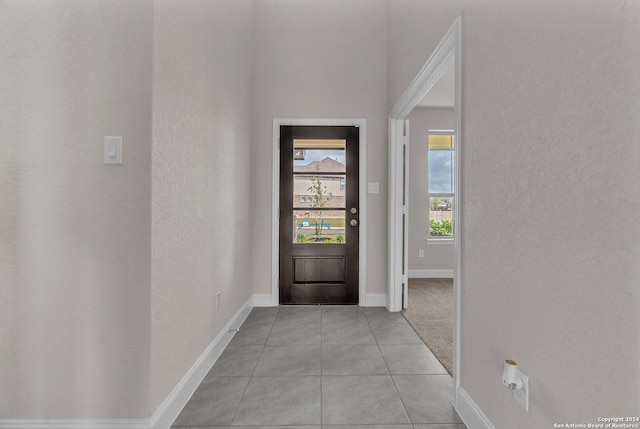 foyer entrance with light tile patterned flooring and baseboards